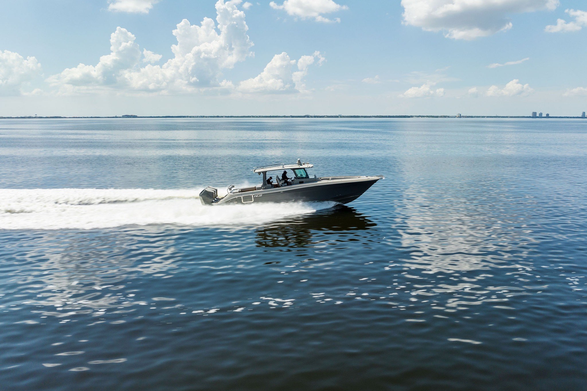 2023 HCB 42 Lujo boat cruising on open water under a clear sky.