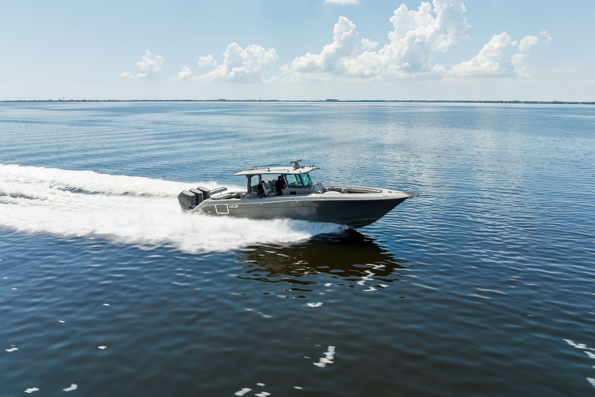 2023 HCB 42 Lujo boat cruising on calm water under a clear sky.