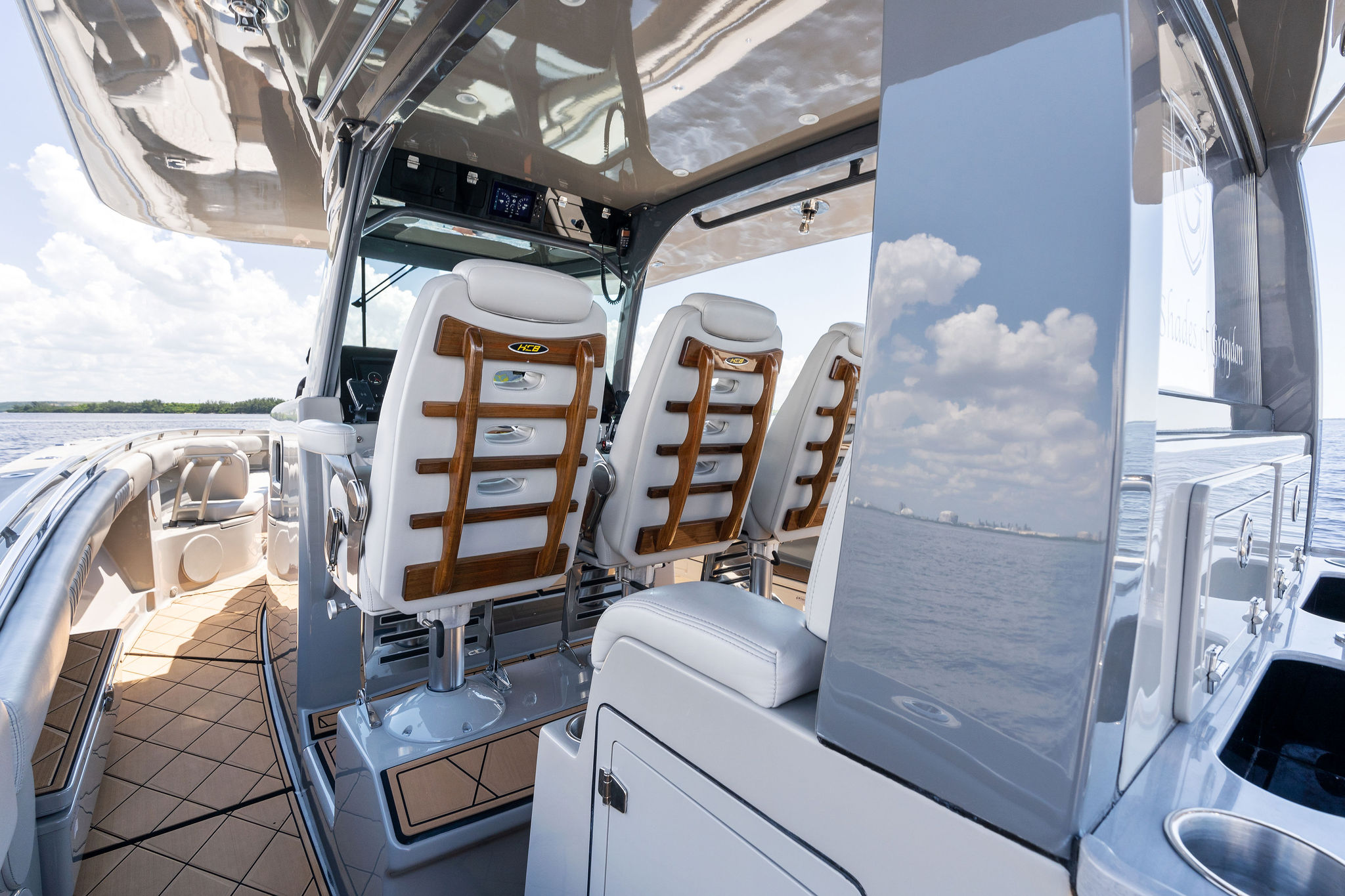 Interior view of 2023 HCB 42 Lujo boat with luxurious seating and ocean backdrop.