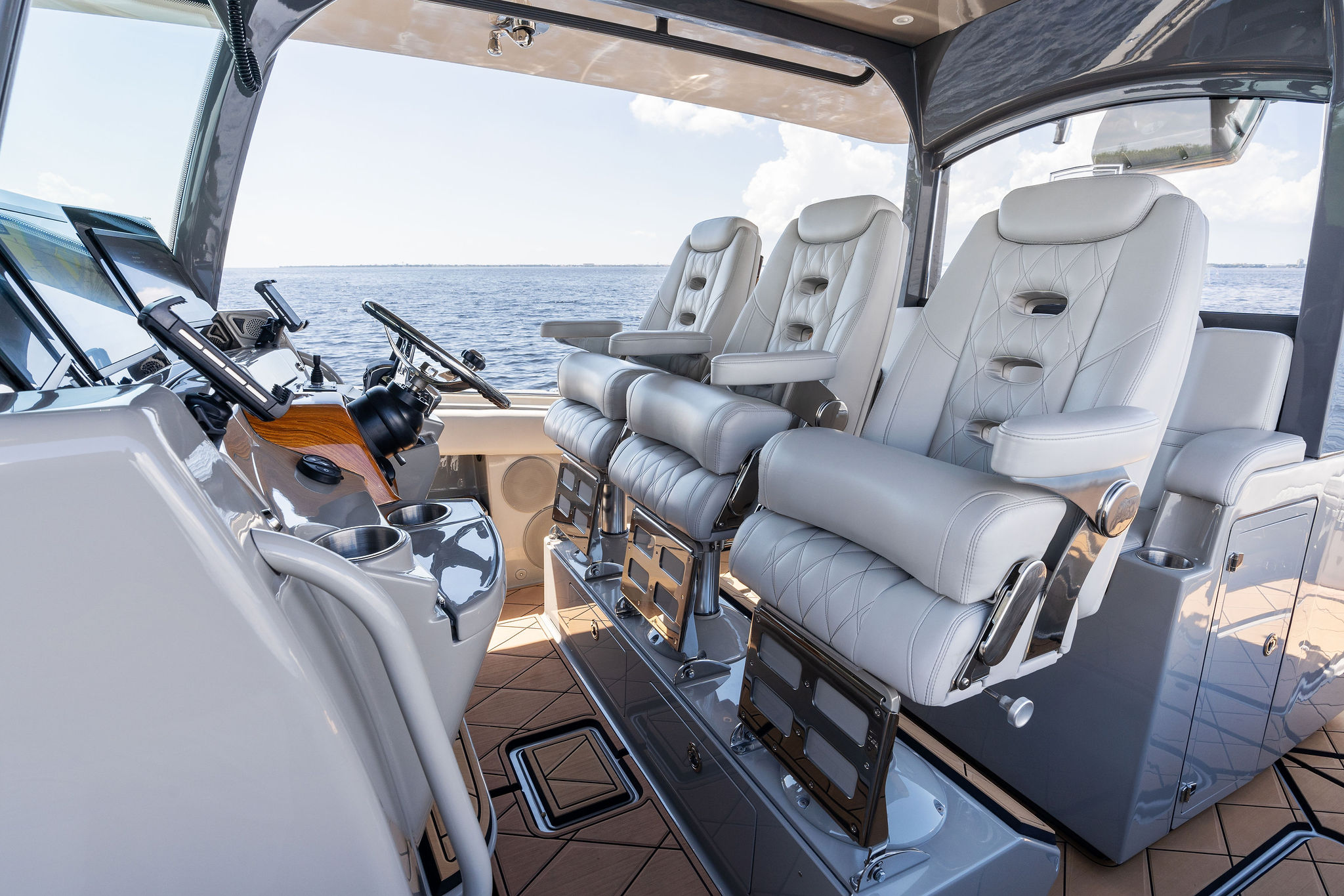 Luxurious helm seating on 2023 HCB 42 Lujo boat, featuring modern controls and ocean view.