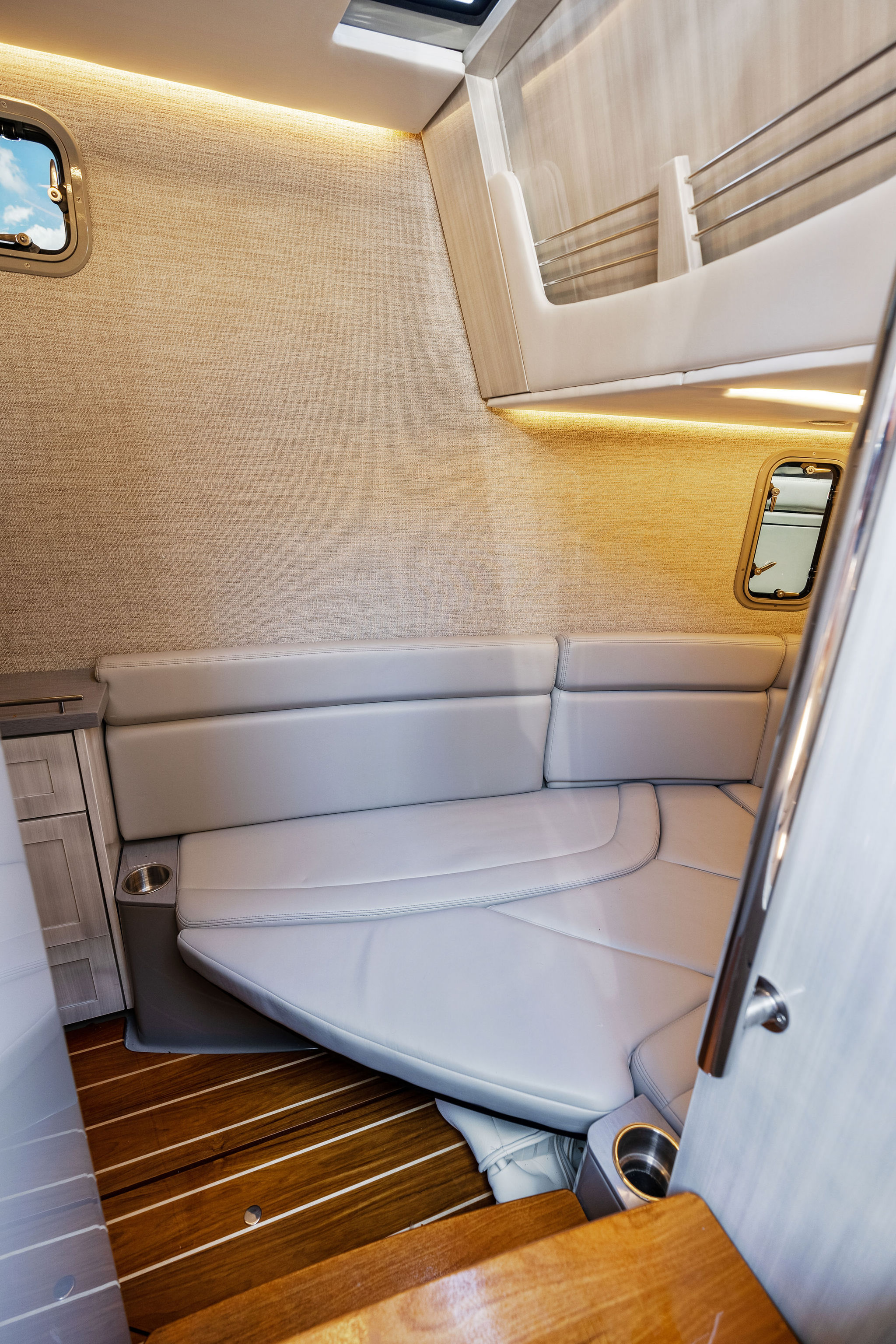Luxurious interior cabin of 2023 HCB 42 Lujo boat with elegant seating and wood flooring.