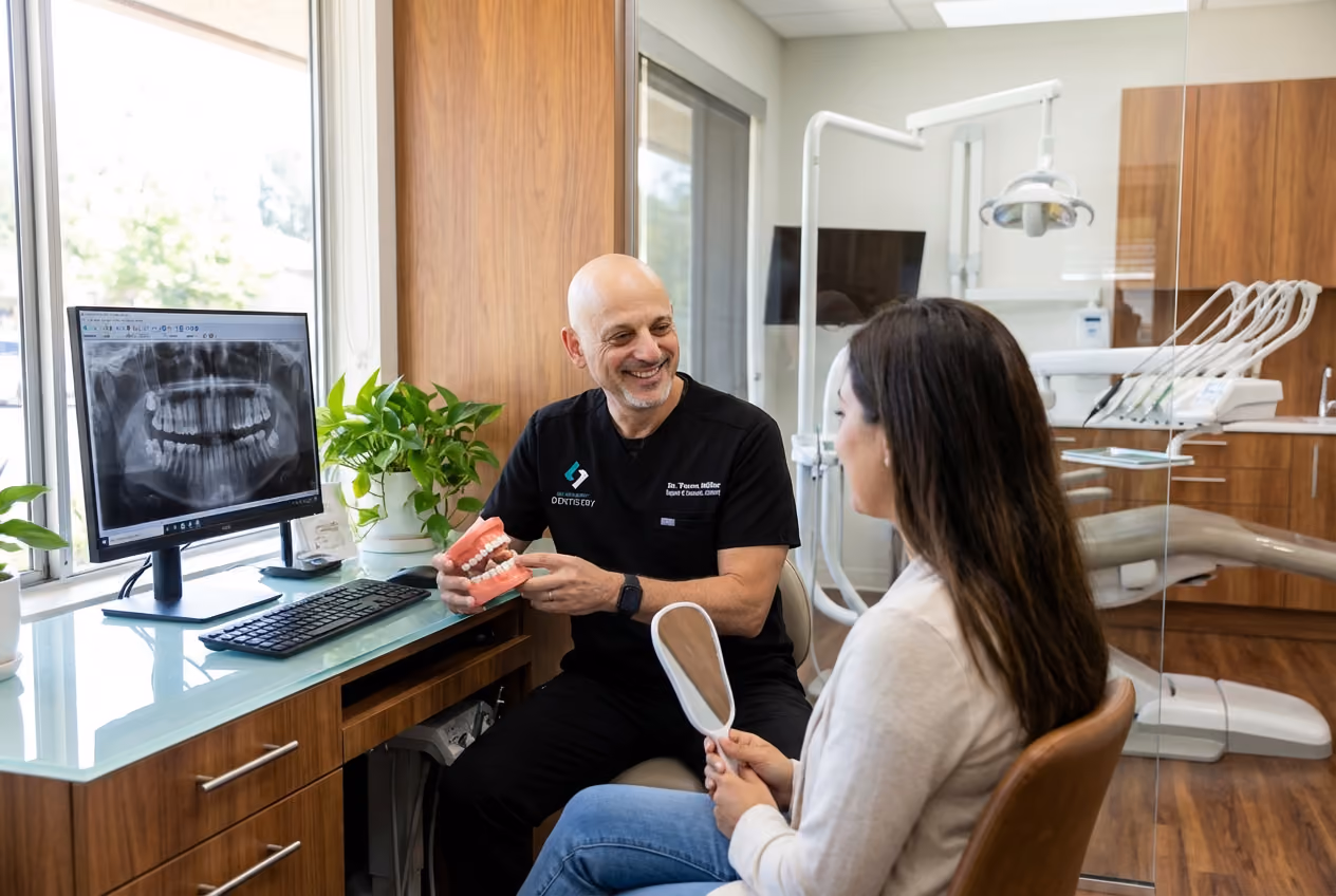 A Clairemont Dentistry dentist reviews dental X-rays with a patient seated in a bright consultation room, using a tablet while discussing treatment options.