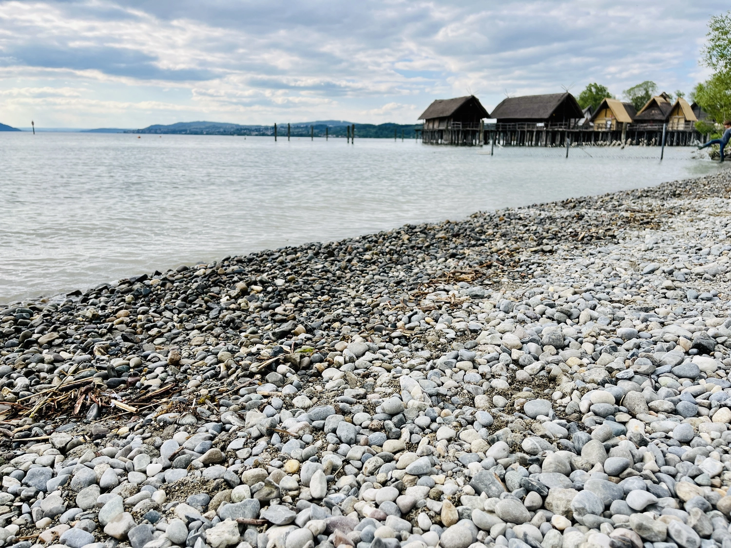 Holzbrücke über Wasser mit Hütten am Ufer in Uhldingen Mühlhofen, ideal für Luxus-Ferienwohnungen am Bodensee.
