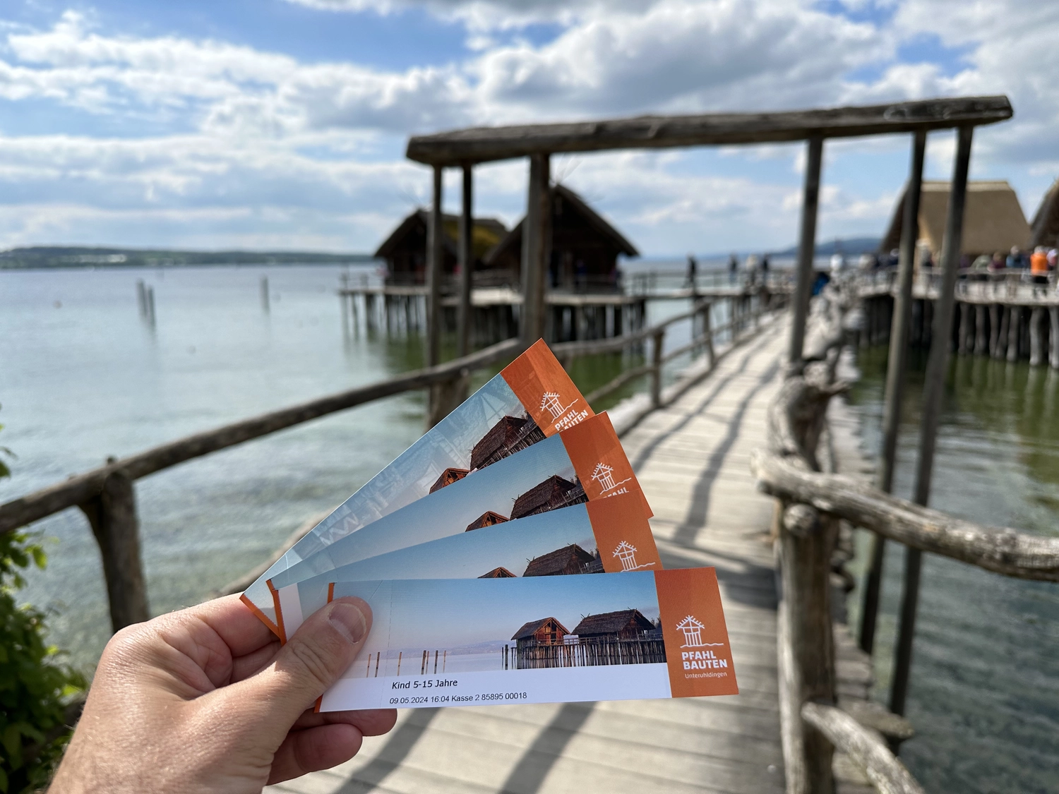 Holzbrücke über Wasser mit Hütten am Ufer in Uhldingen Mühlhofen, ideal für Luxus-Ferienwohnungen am Bodensee.