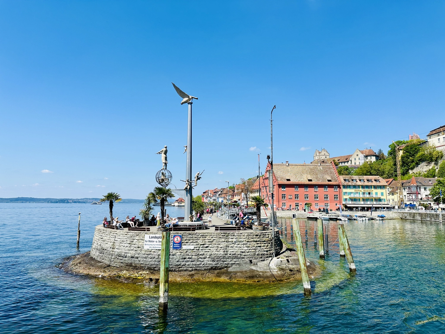 Holzbrücke über Wasser mit Hütten am Ufer in Uhldingen Mühlhofen, ideal für Luxus-Ferienwohnungen am Bodensee.