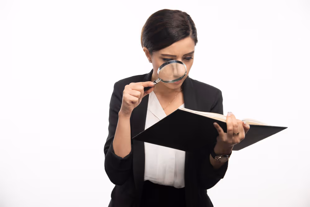 A woman reading using a magnifying glass