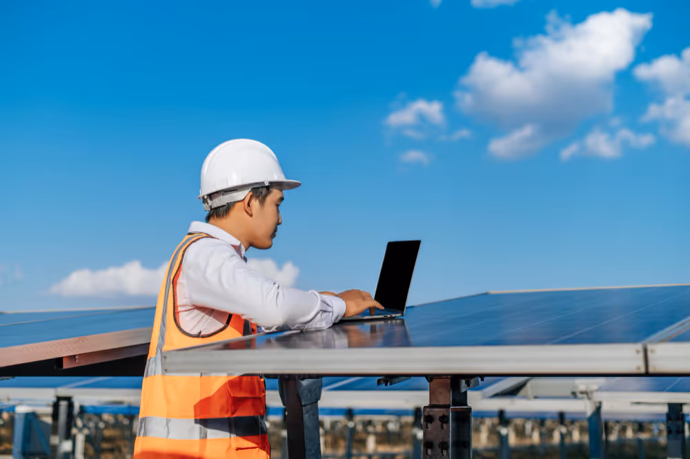 Young asian inspector engineer man use laptop computer working at solar