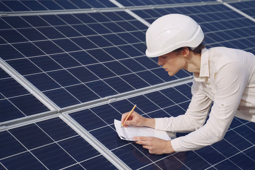 A businessman in white writing on top of solar panels