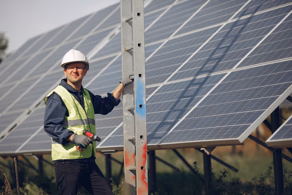 A technician holding a ladder next to solar panel