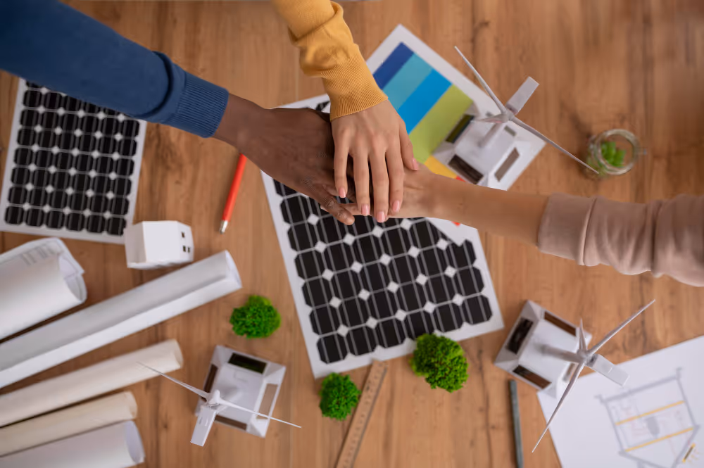 Three hands putting together above a solar panel
