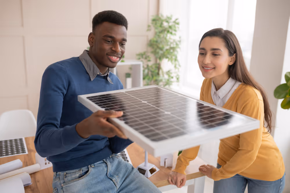 A woman and a man holding a solar panel