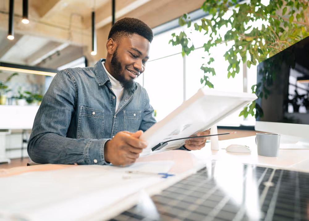 A man smiling while checking the plan