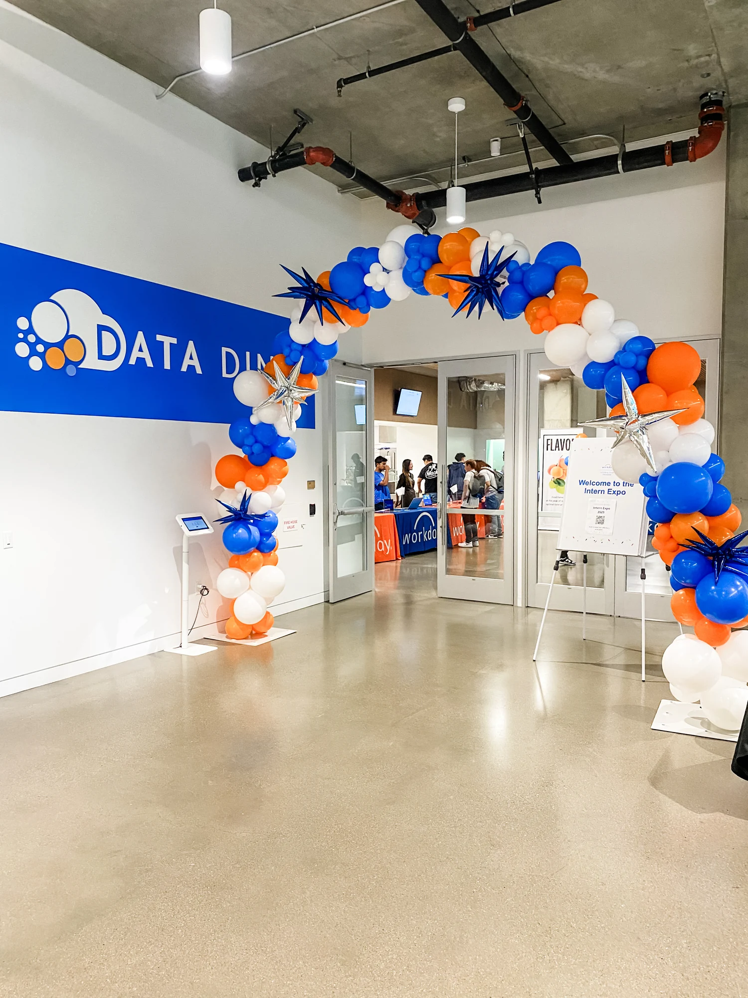 Blue, orange and white balloon arch framing a Data Divas event entrance