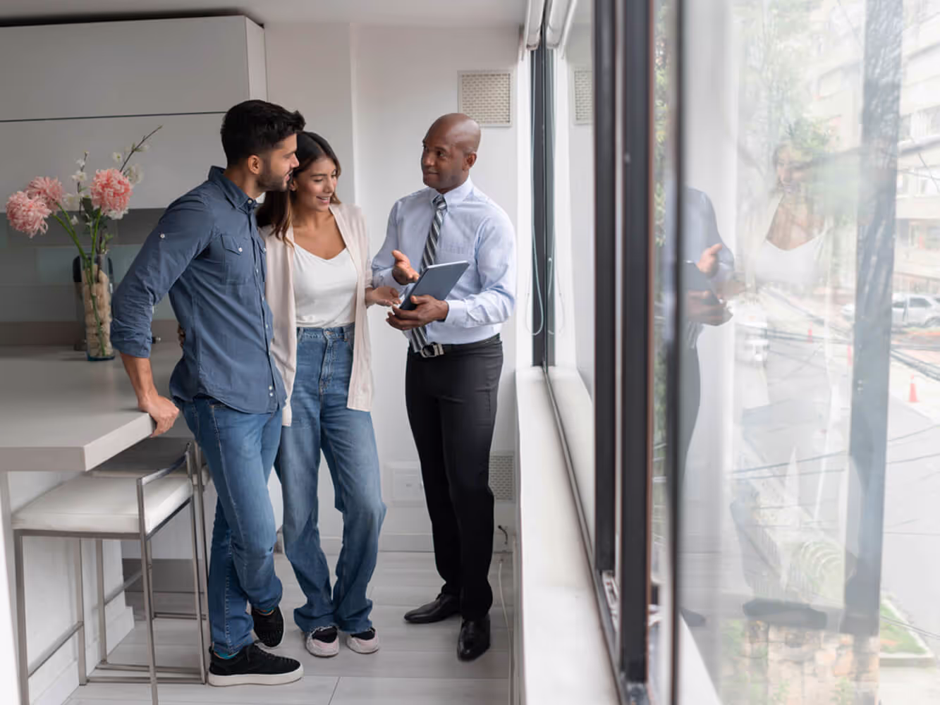 Real estate agent or landlord is discussing a lease agreement with a young man and woman in a new rental unit