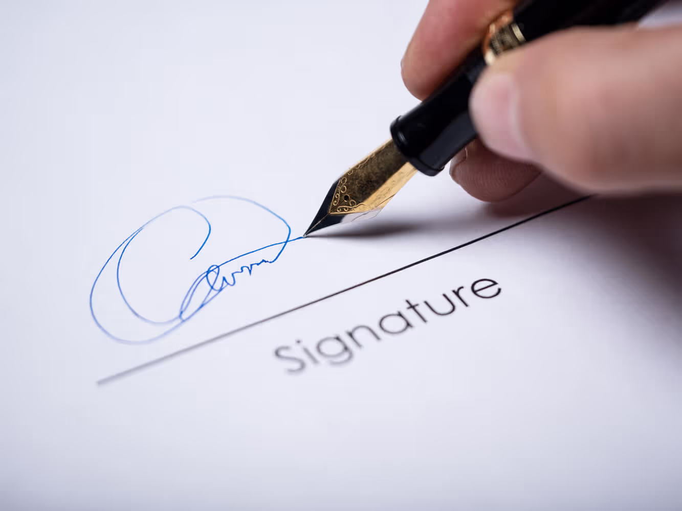 An up close view of a person signing a legal document