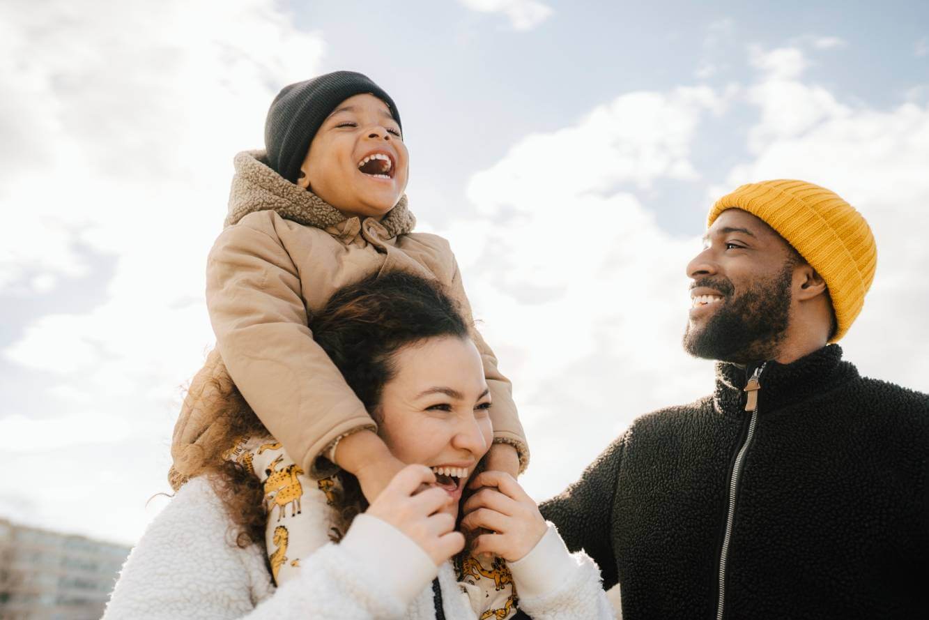 happy father, mother and young child outside