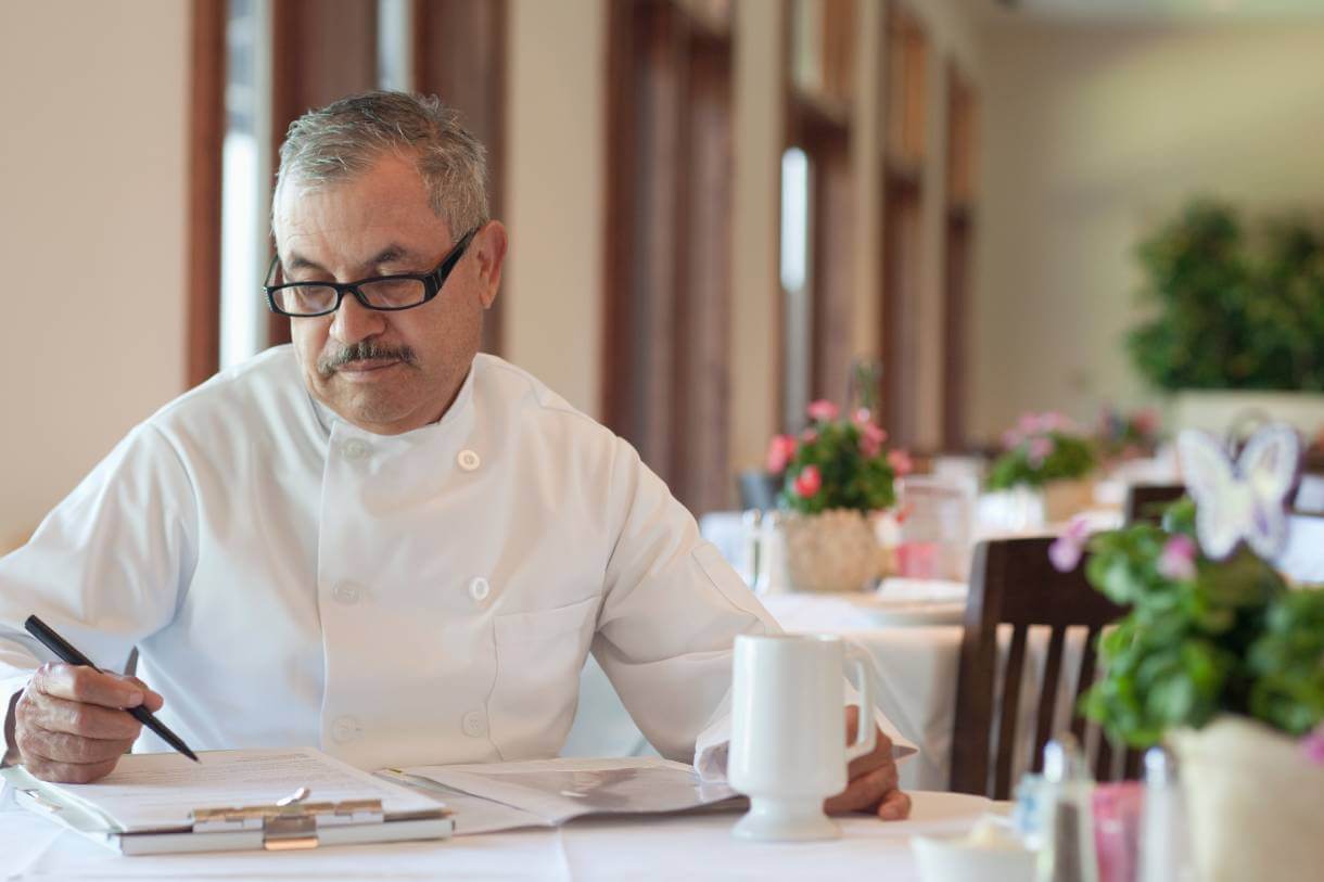 small business owner and chef reviewing debt collection letters