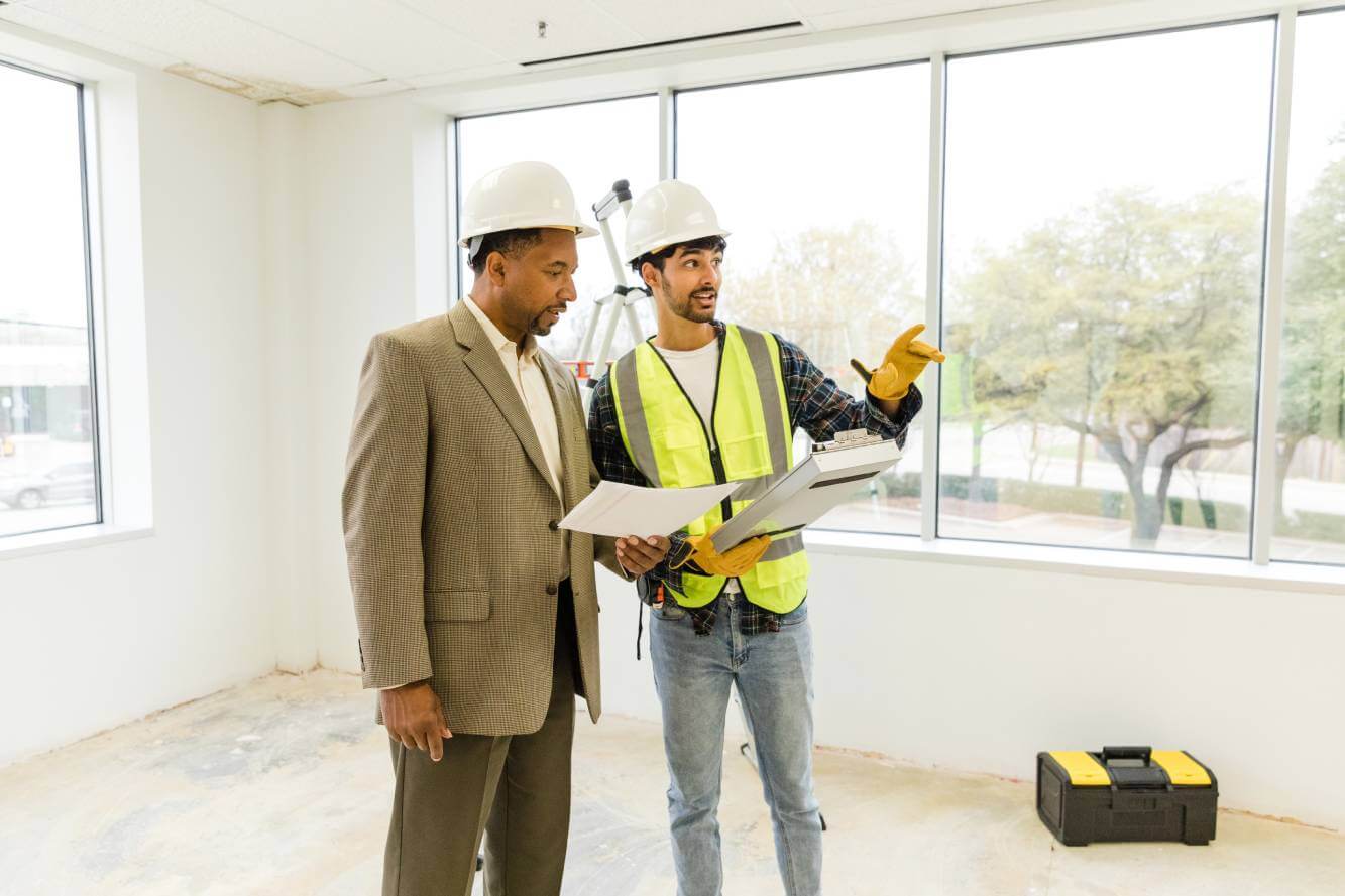 independent contractor reviewing scope of work with business owner on job remodel site
