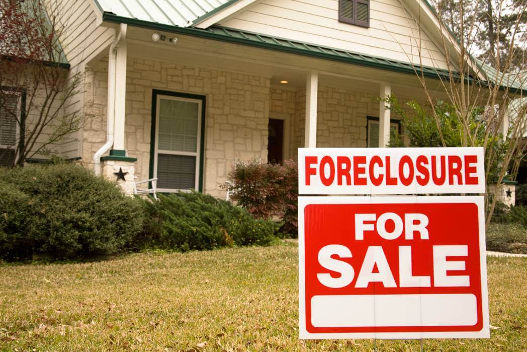 foreclosure for sale sign in yard of home