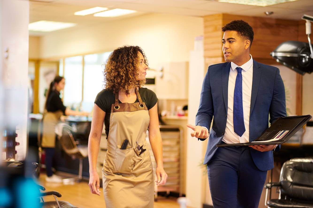 business owner talking to small business lawyer as they walk in business hair salon