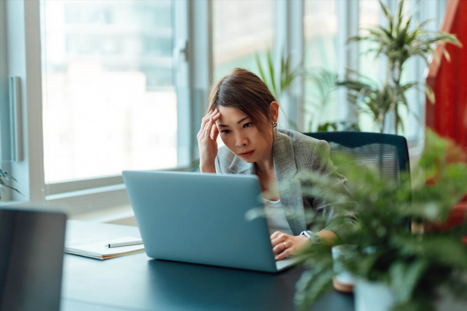 Tired Asian businesswoman working on a laptop computer in the office