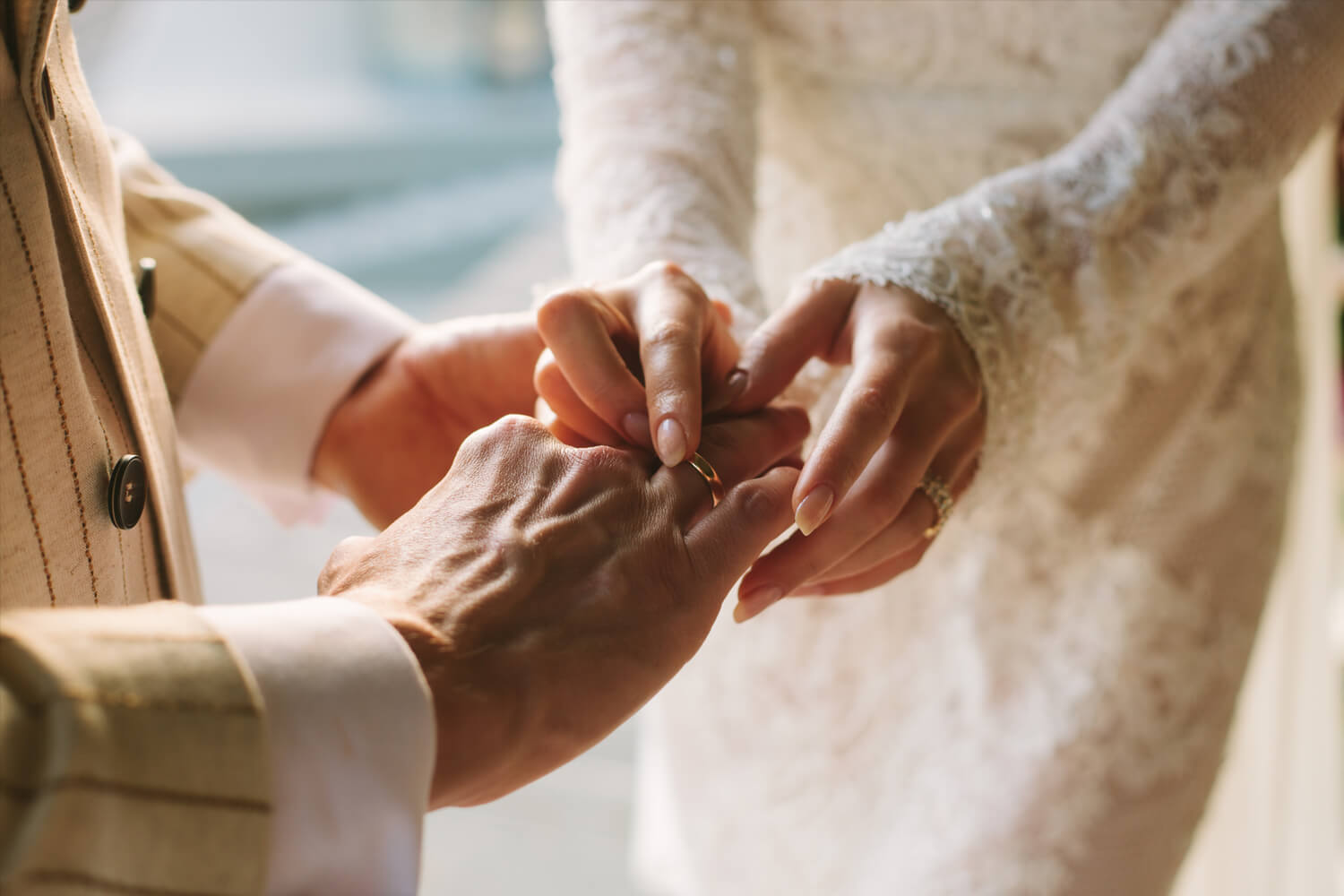 Bride putting ring on groom's finger