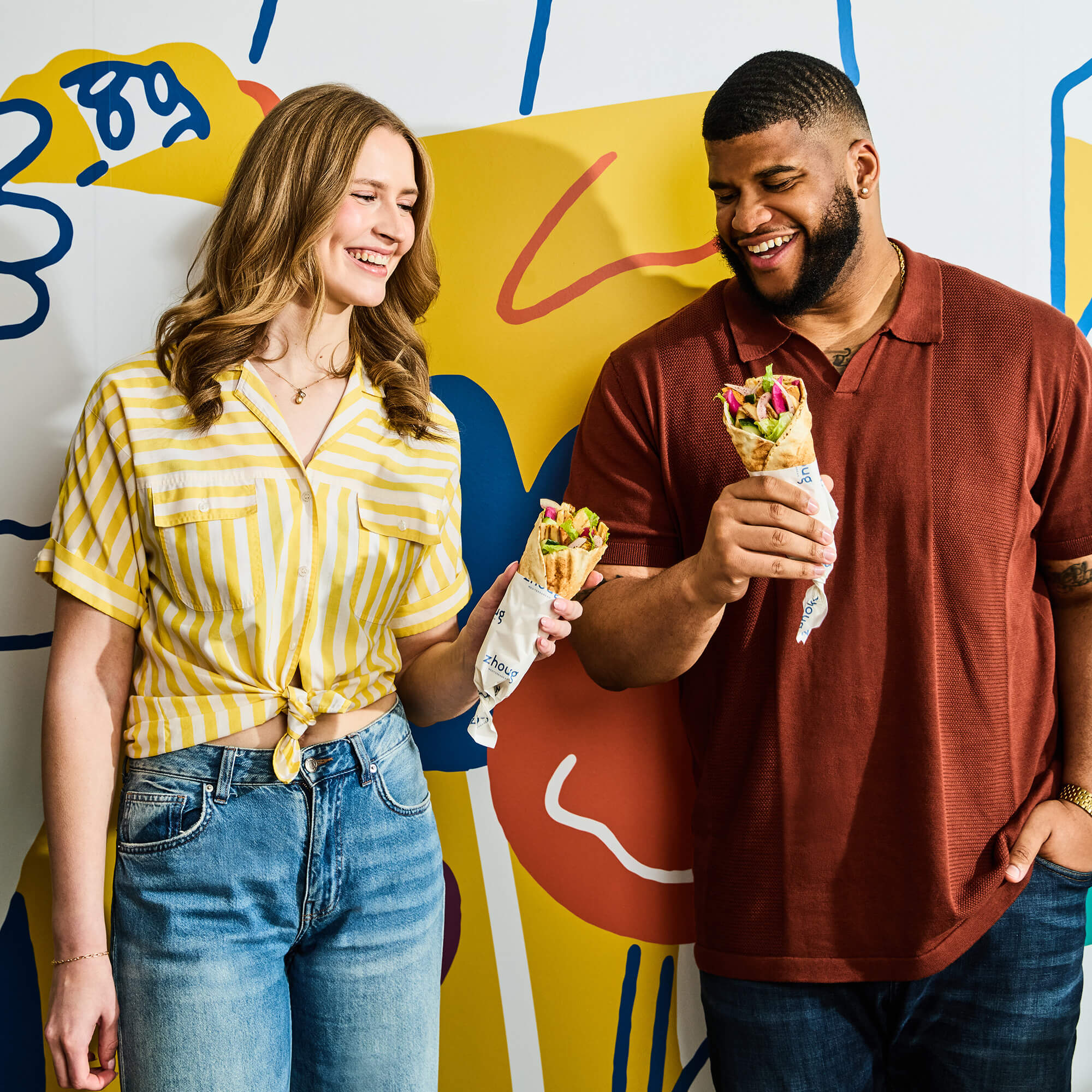 Young woman and man enjoying their pita wraps.