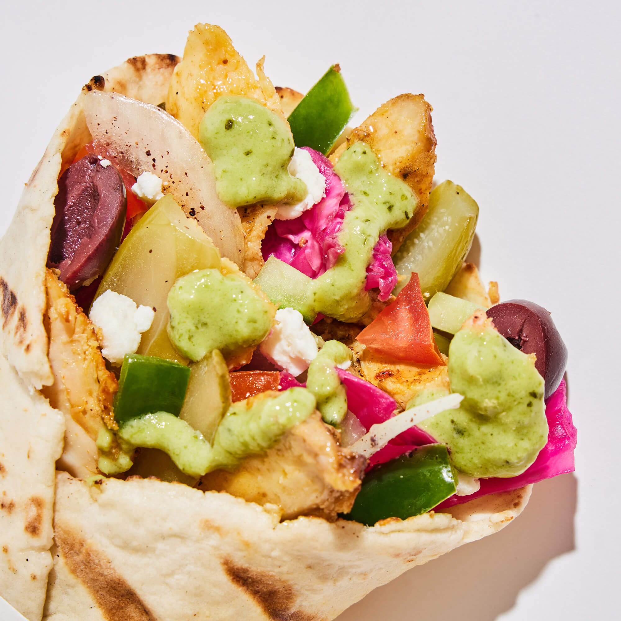 Zhoug sauce close up on a chicken shawarma pita.