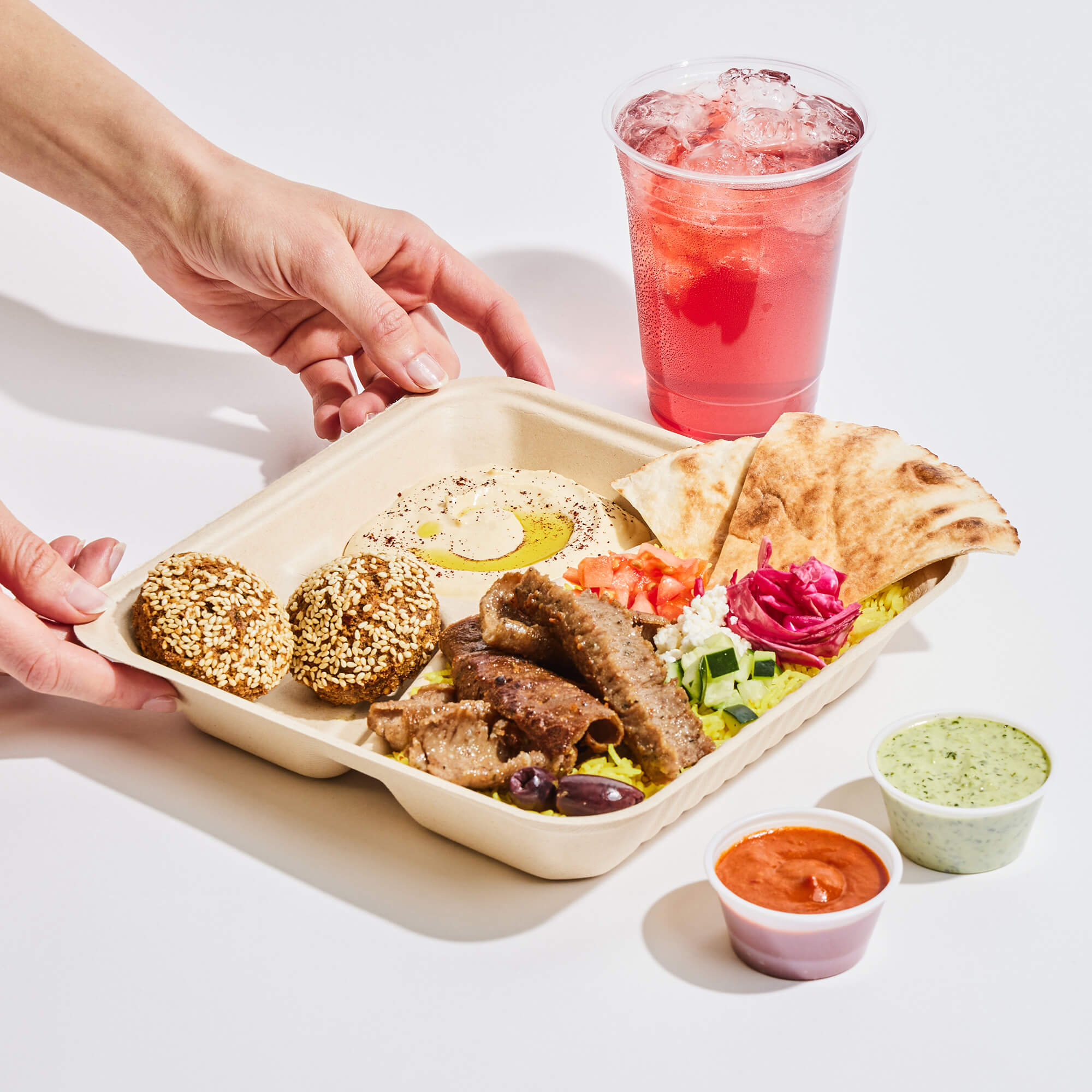 Gyro platter, drink, and sauces.