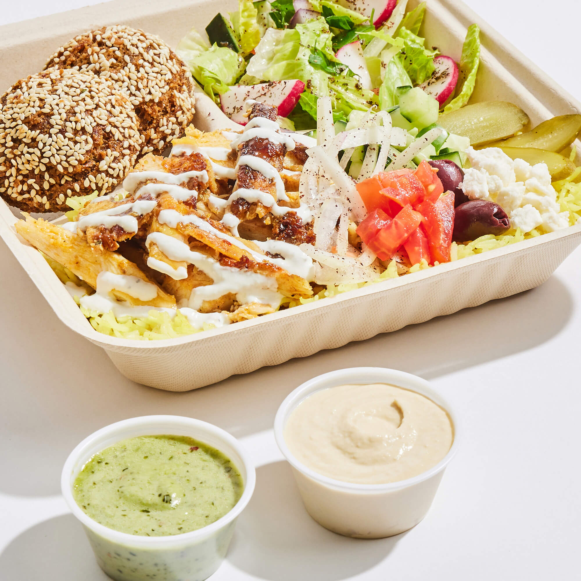 Chicken shawarma platter with sauces.