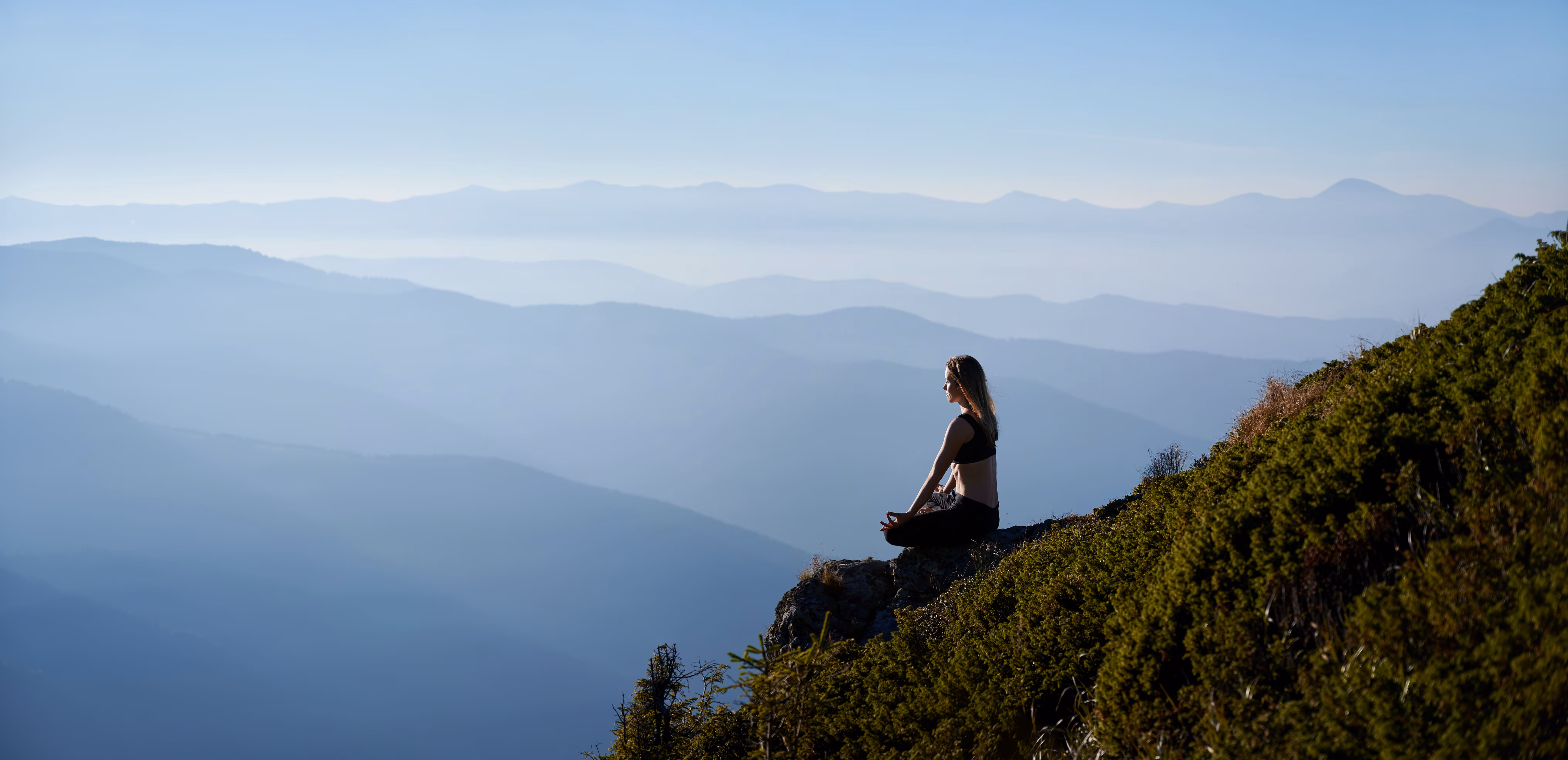 A young woman meditating in the himalayas.