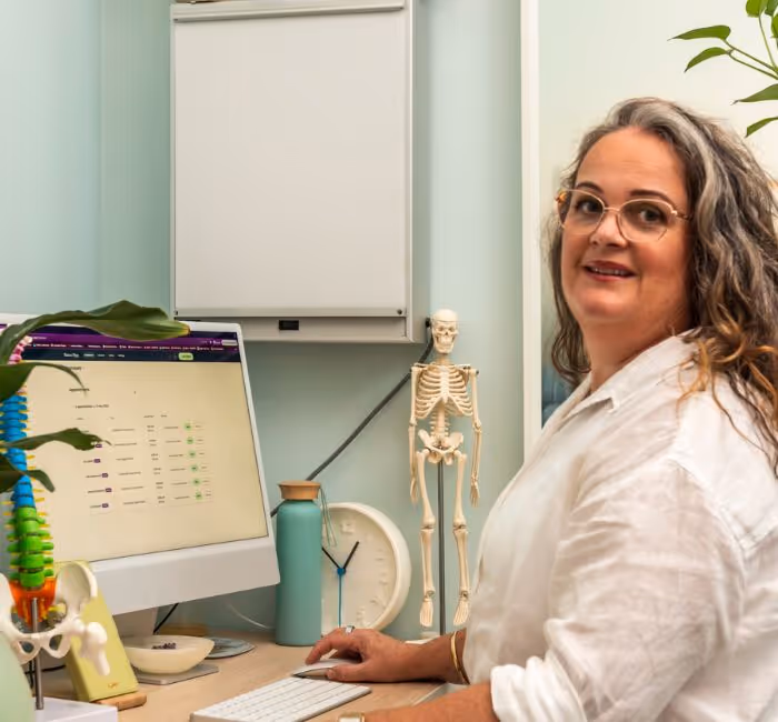 A woman sitting at a desk with a computer.