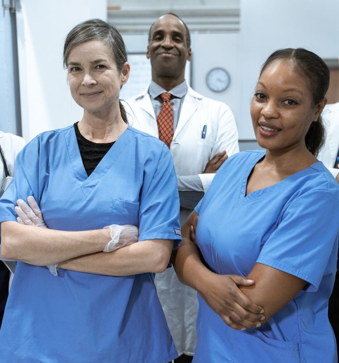 Two female doctors wearing blue scrubs.
