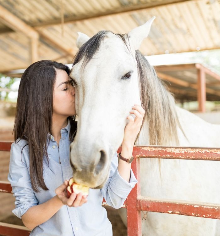 A woman kissing a horse.