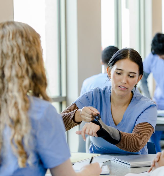 A woman in a blue shirt is talking to another woman.