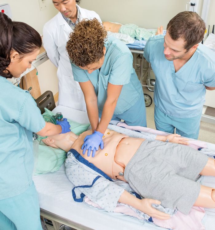 A group of doctors working on a dummy.