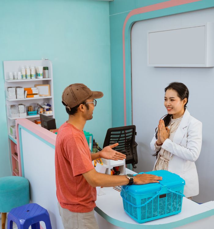 A man and woman are talking in a store with a blue basket on the counter.