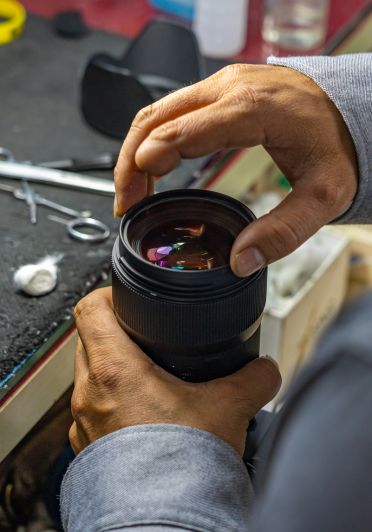 A man holding a camera lens.