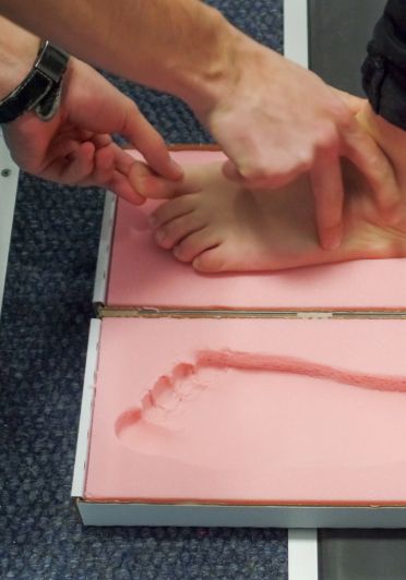 A person is positioning a foot pad on a table.