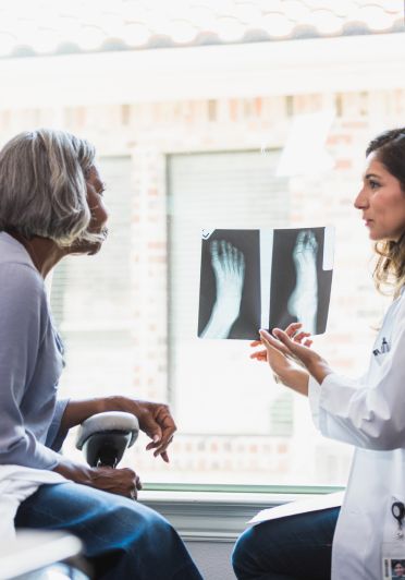 A woman consults with a doctor about her foot issue during a medical appointment.