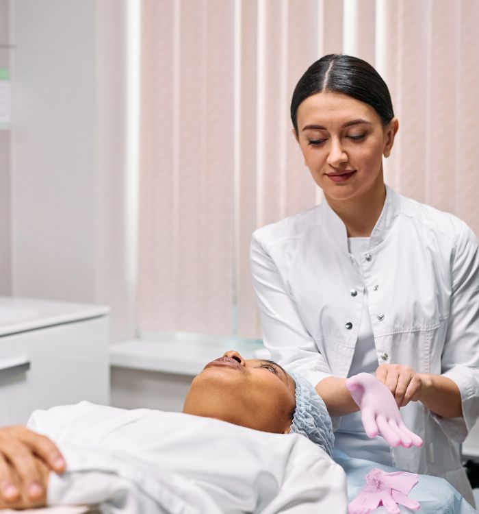 A woman is undergoing a facial treatment administered by a doctor.