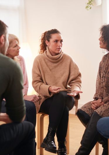 A circle of people talking and interacting with one another in a collaborative setting.