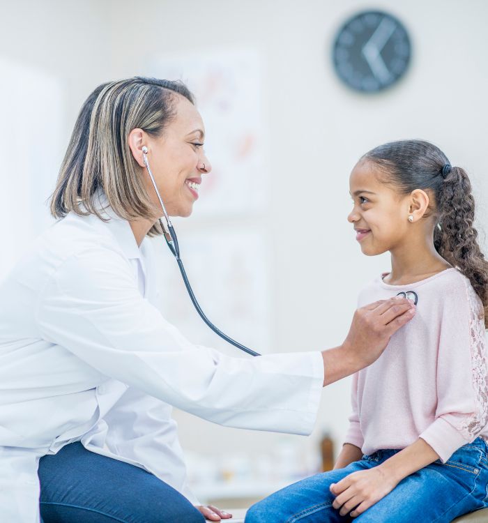 A female doctor conducts a chest examination on a young girl.