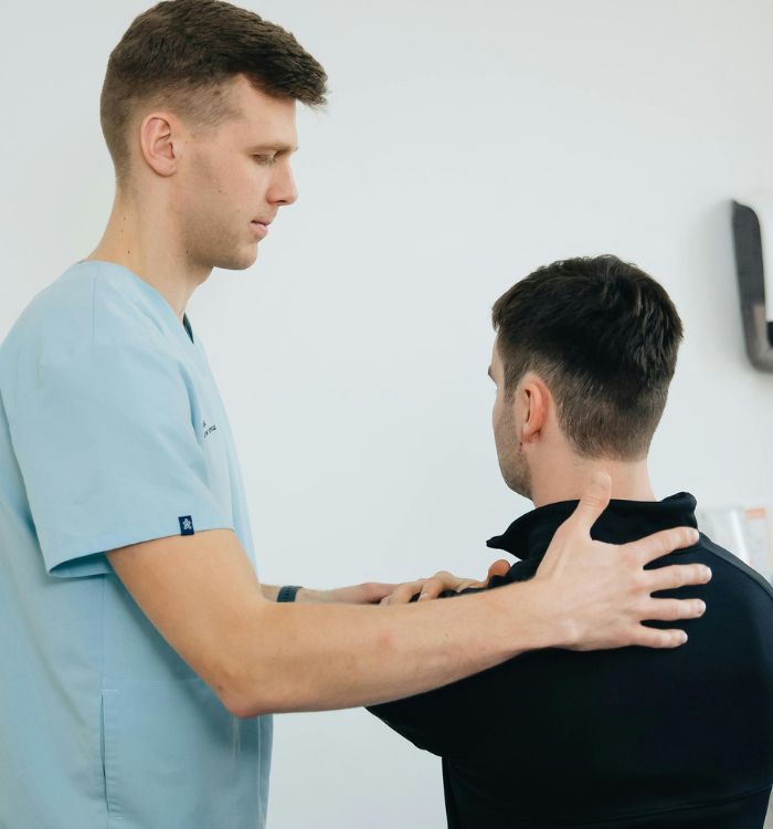 A man receives a back examination from a doctor.