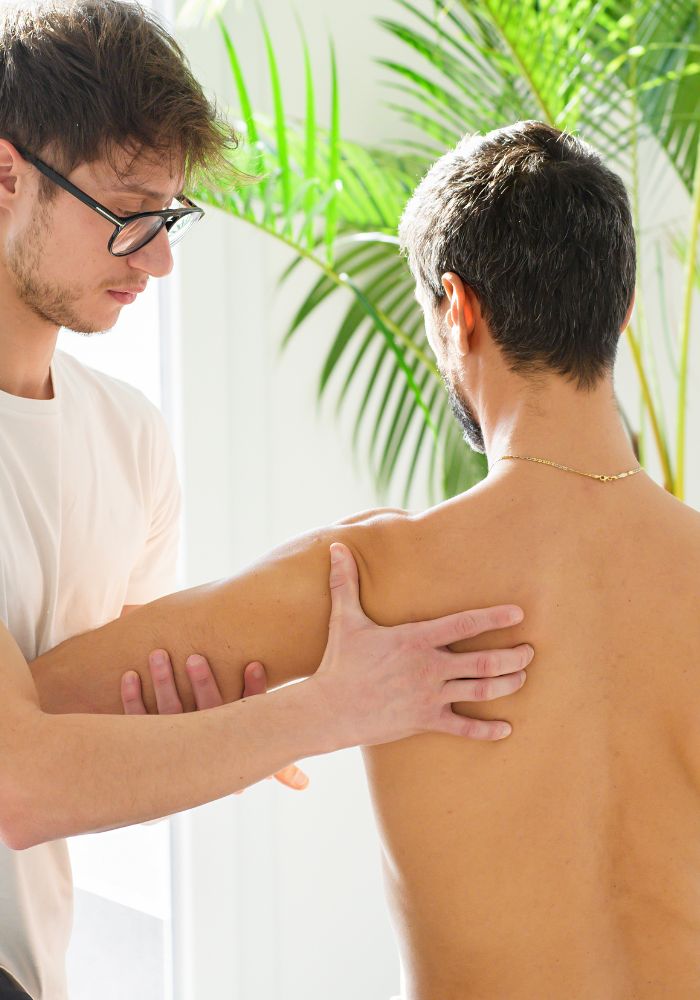 A man is being massaged on his back by another man.