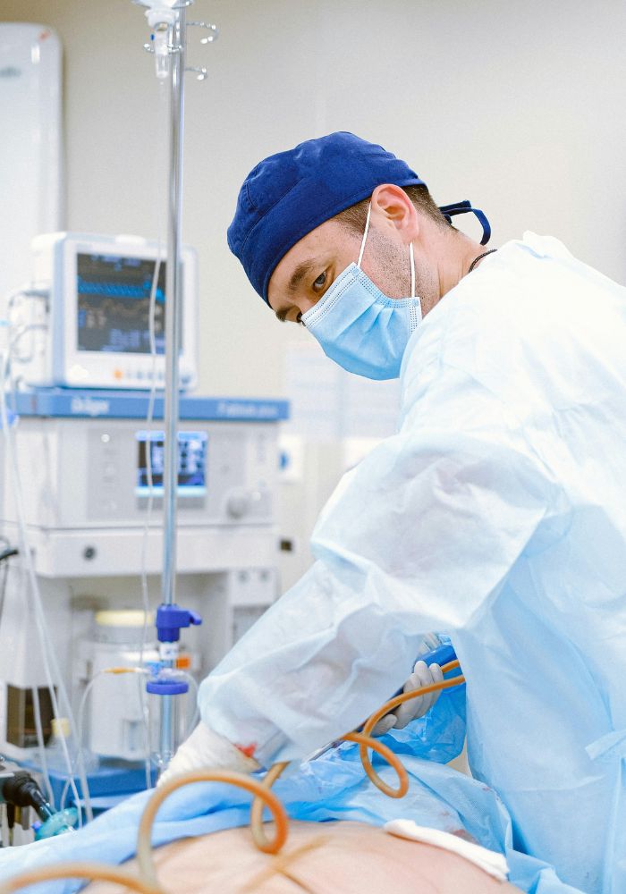 A surgeon in scrubs performing an operation.