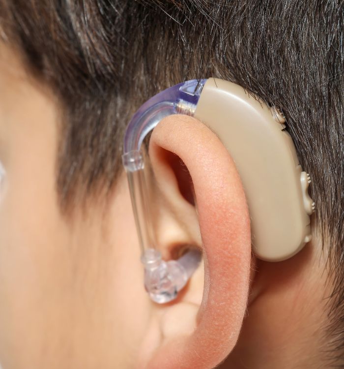 A boy with a hearing aid on his ear.