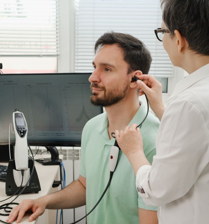 A man wearing a green shirt has a stethoscope on his chest.