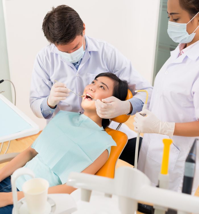A woman getting her teeth cleaned by a dentist.
