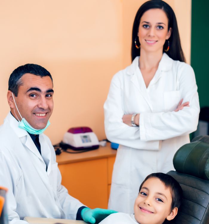 A young boy is getting his teeth cleaned by a dentist.